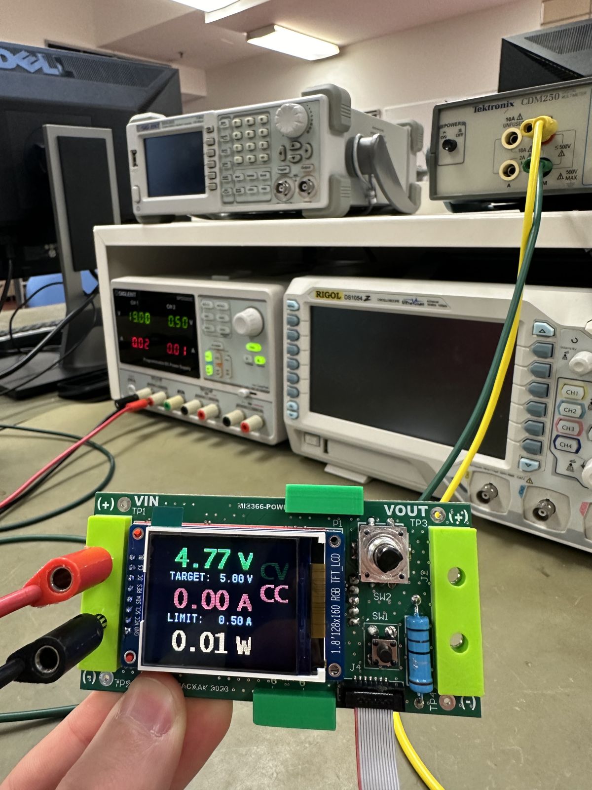 The supply running on a lab bench, screen showing 4.77 V against a 5.00 V target